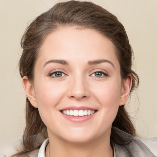 Joyful white young-adult female with medium  brown hair and grey eyes