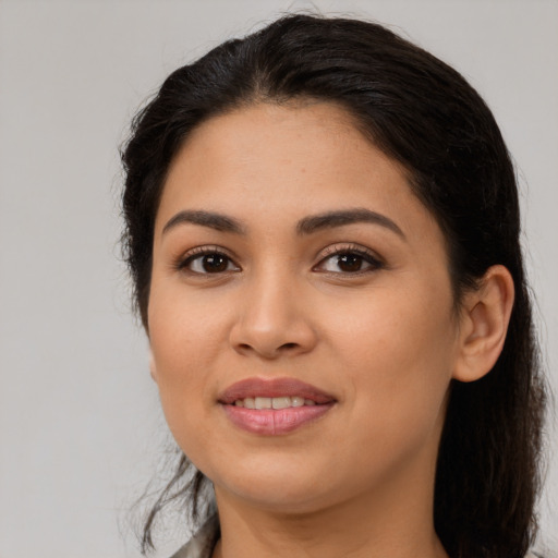 Joyful latino young-adult female with long  black hair and brown eyes