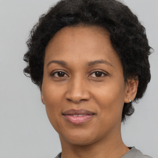 Joyful black adult female with short  black hair and brown eyes