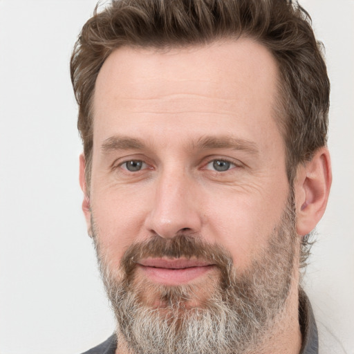 Joyful white adult male with short  brown hair and grey eyes