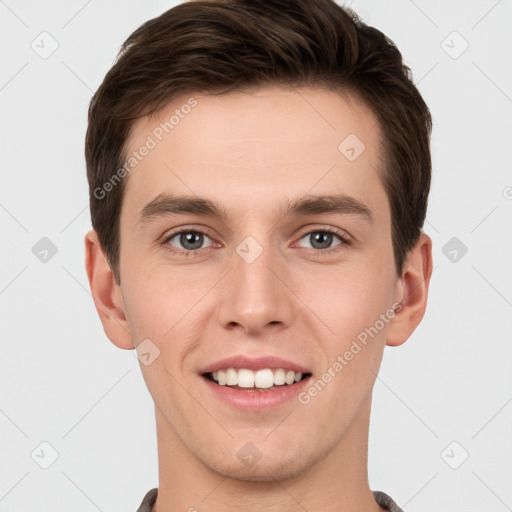 Joyful white young-adult male with short  brown hair and grey eyes