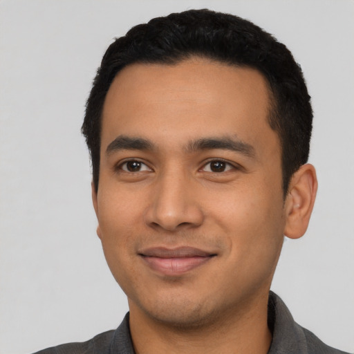 Joyful latino young-adult male with short  black hair and brown eyes