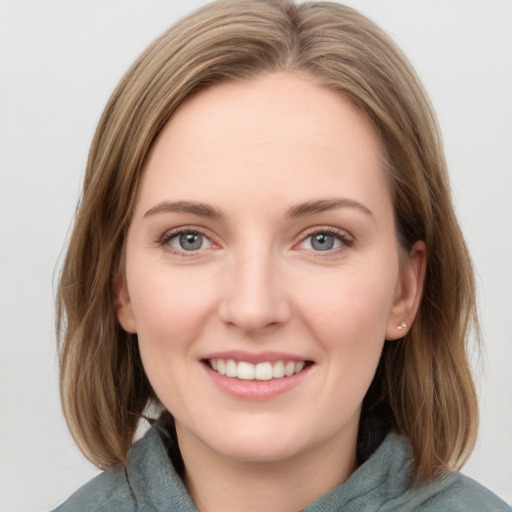 Joyful white young-adult female with medium  brown hair and blue eyes