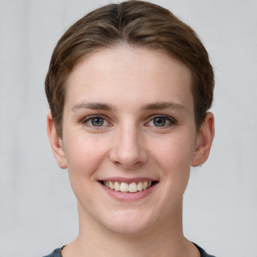 Joyful white young-adult female with short  brown hair and grey eyes