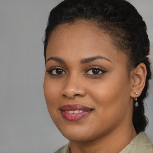 Joyful black young-adult female with long  brown hair and brown eyes