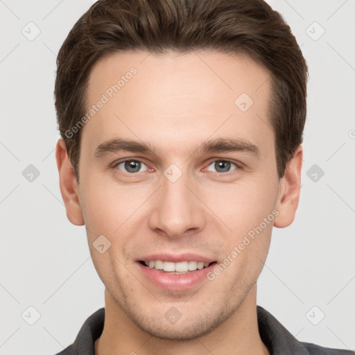 Joyful white young-adult male with short  brown hair and grey eyes