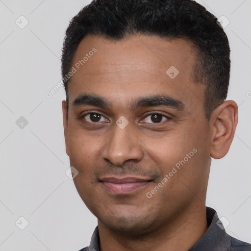 Joyful black young-adult male with short  black hair and brown eyes