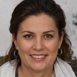 Joyful white adult female with medium  brown hair and brown eyes