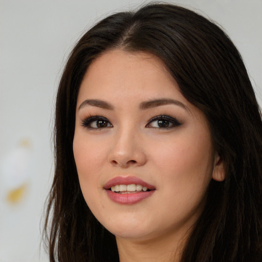 Joyful asian young-adult female with long  brown hair and brown eyes