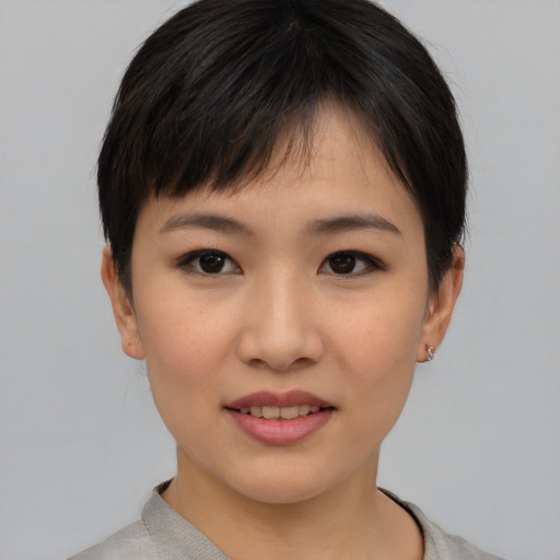 Joyful asian young-adult female with short  brown hair and brown eyes