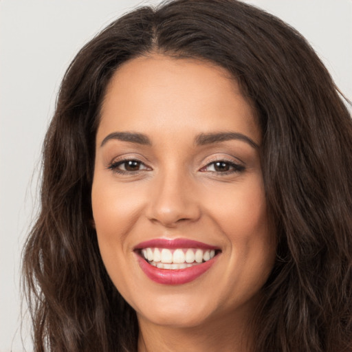 Joyful white young-adult female with long  brown hair and brown eyes