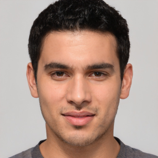 Joyful white young-adult male with short  black hair and brown eyes