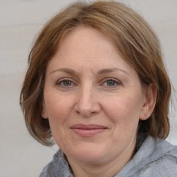 Joyful white adult female with medium  brown hair and blue eyes