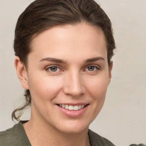 Joyful white young-adult female with short  brown hair and grey eyes