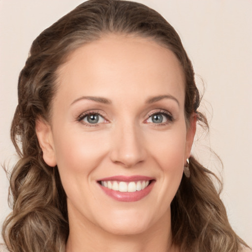 Joyful white young-adult female with long  brown hair and blue eyes