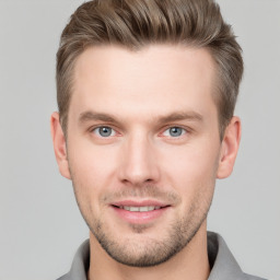 Joyful white young-adult male with short  brown hair and grey eyes