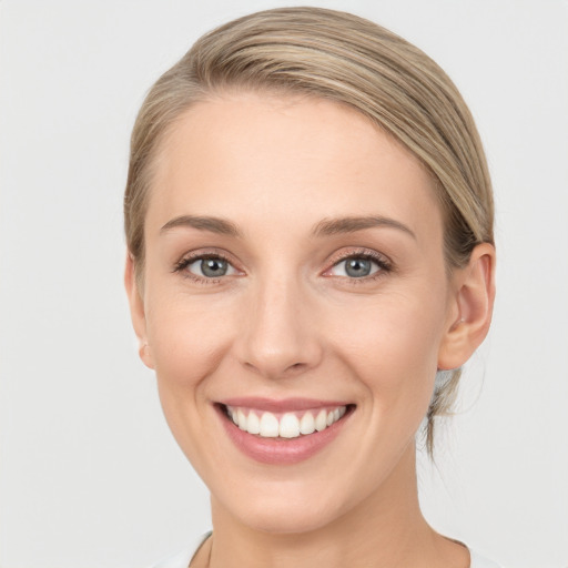 Joyful white young-adult female with medium  brown hair and grey eyes