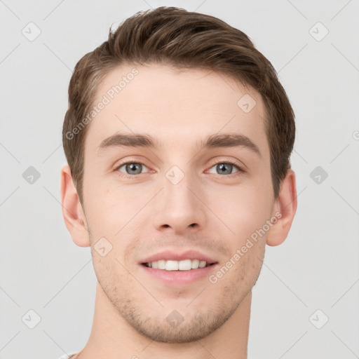 Joyful white young-adult male with short  brown hair and grey eyes