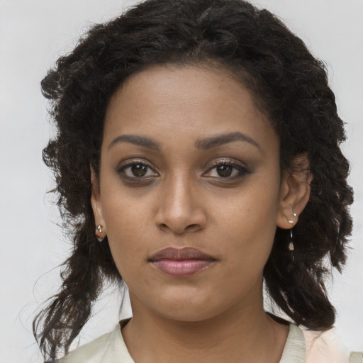 Joyful black young-adult female with long  brown hair and brown eyes