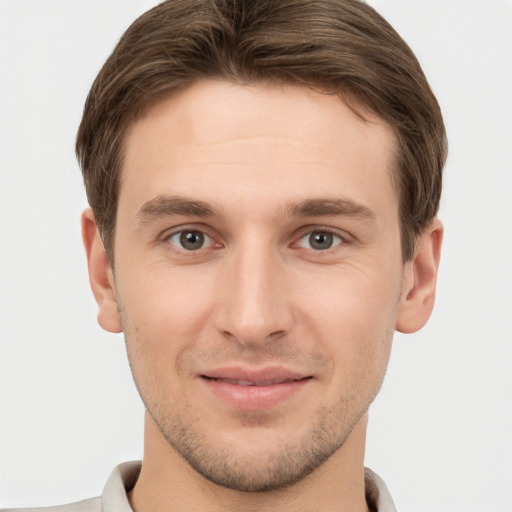 Joyful white young-adult male with short  brown hair and grey eyes