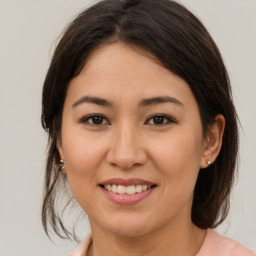 Joyful latino young-adult female with medium  brown hair and brown eyes