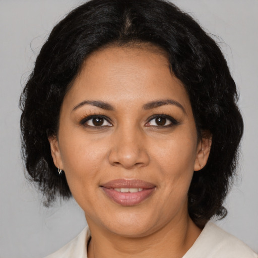 Joyful latino adult female with medium  brown hair and brown eyes