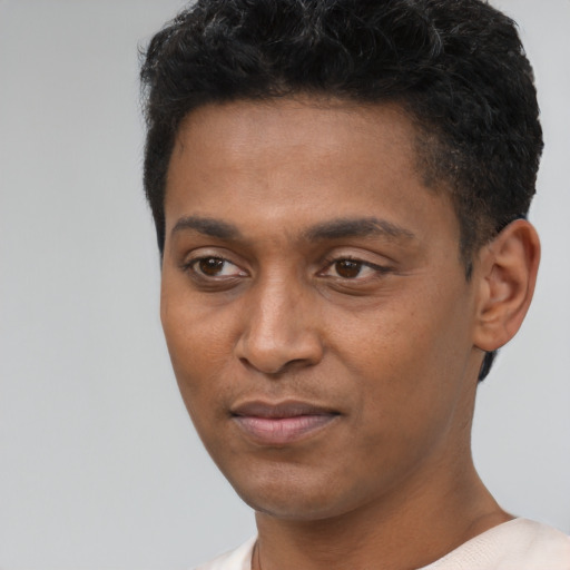 Joyful black young-adult male with short  black hair and brown eyes
