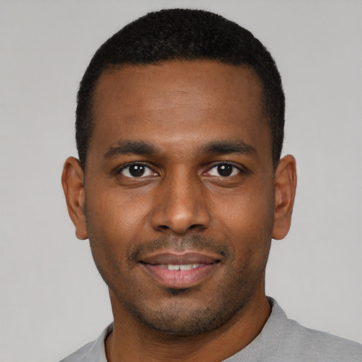 Joyful black young-adult male with short  brown hair and brown eyes