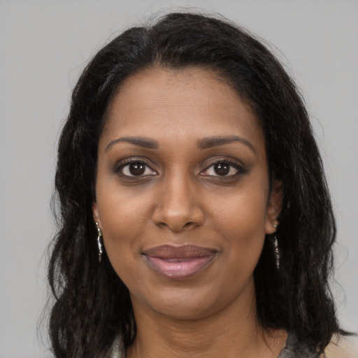 Joyful black young-adult female with long  brown hair and brown eyes