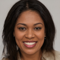 Joyful black young-adult female with long  brown hair and brown eyes