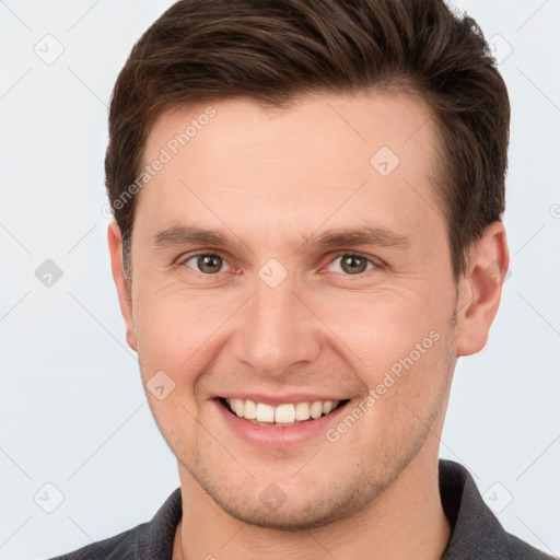 Joyful white young-adult male with short  brown hair and grey eyes