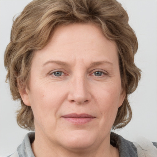 Joyful white adult female with medium  brown hair and grey eyes