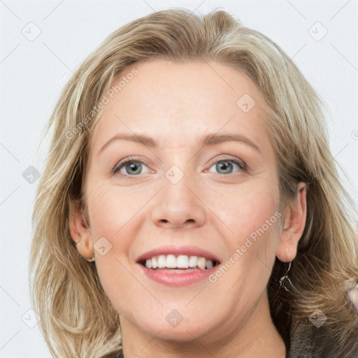 Joyful white adult female with medium  brown hair and blue eyes