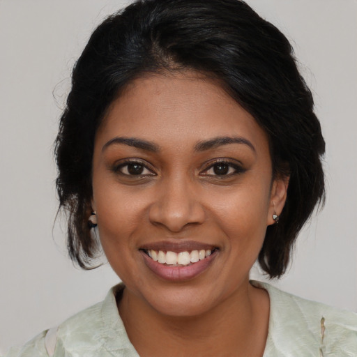 Joyful black young-adult female with medium  black hair and brown eyes