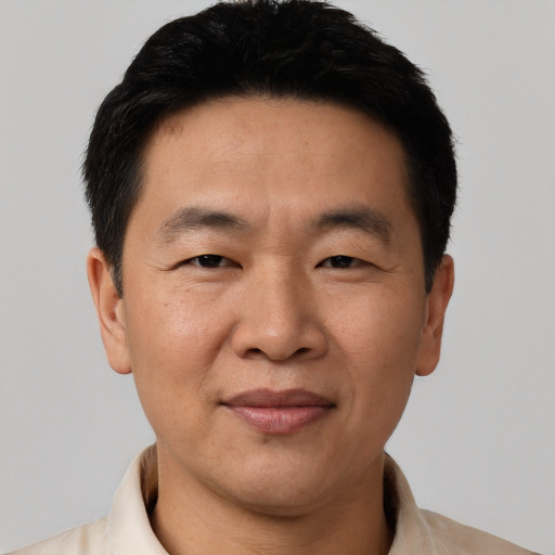Joyful asian adult male with short  black hair and brown eyes