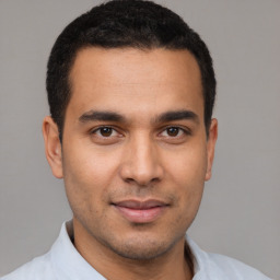 Joyful latino young-adult male with short  black hair and brown eyes