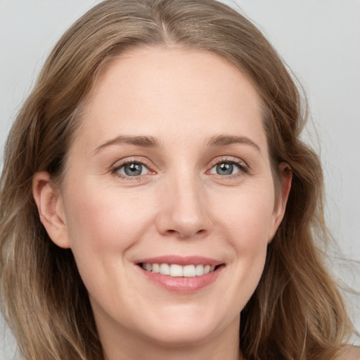 Joyful white young-adult female with long  brown hair and blue eyes