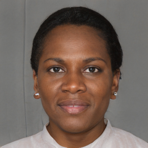 Joyful black young-adult female with short  black hair and brown eyes