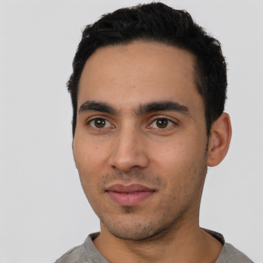 Joyful latino young-adult male with short  black hair and brown eyes