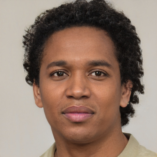 Joyful black young-adult male with short  brown hair and brown eyes