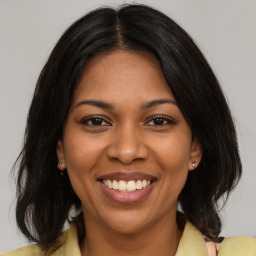 Joyful black young-adult female with medium  brown hair and brown eyes