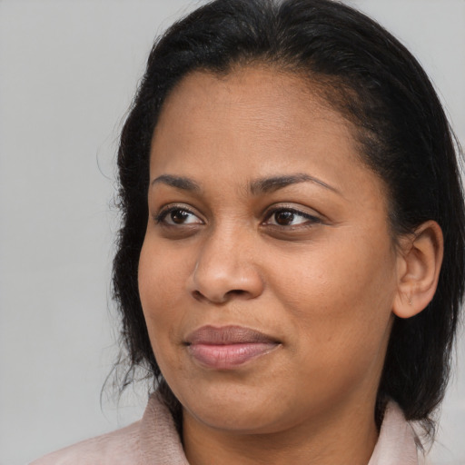 Joyful black adult female with medium  brown hair and brown eyes