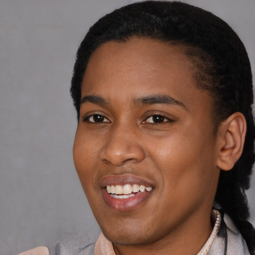 Joyful black young-adult female with short  black hair and brown eyes