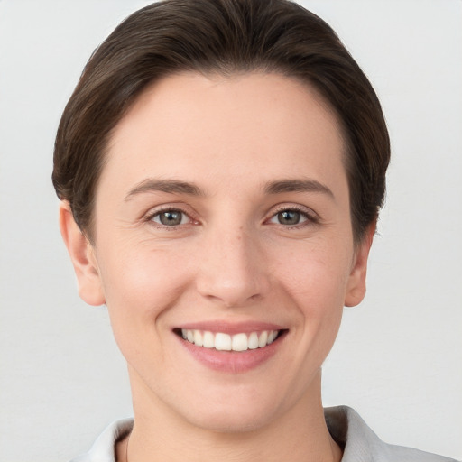 Joyful white young-adult female with short  brown hair and grey eyes