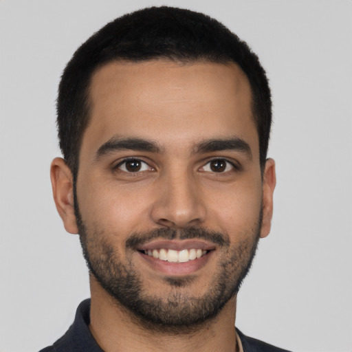 Joyful latino young-adult male with short  brown hair and brown eyes