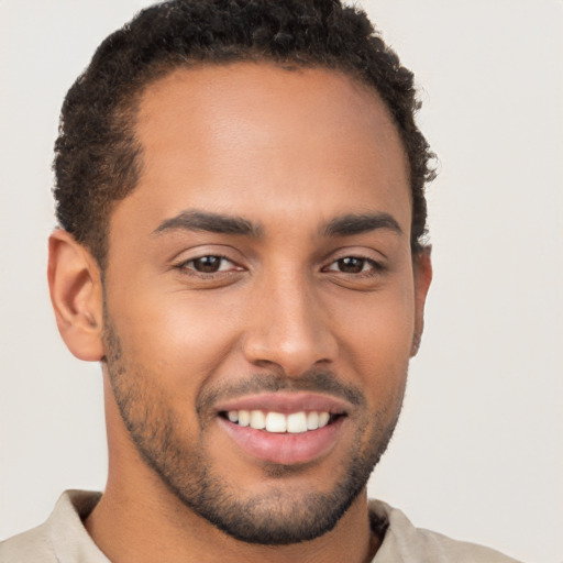 Joyful latino young-adult male with short  brown hair and brown eyes