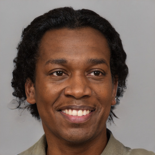 Joyful black adult male with short  black hair and brown eyes