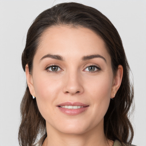 Joyful white young-adult female with medium  brown hair and grey eyes