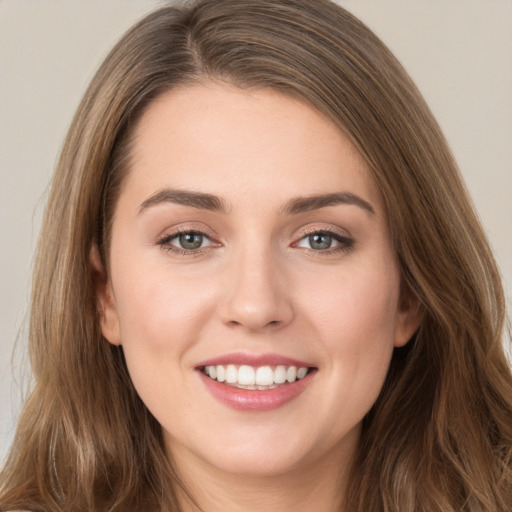 Joyful white young-adult female with long  brown hair and green eyes