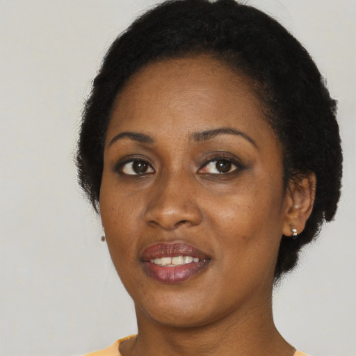 Joyful black young-adult female with short  black hair and brown eyes